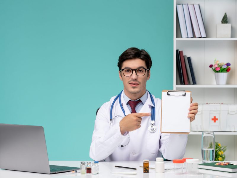 medical-smart-young-doctor-lab-coat-working-remotely-computer-holding-notes